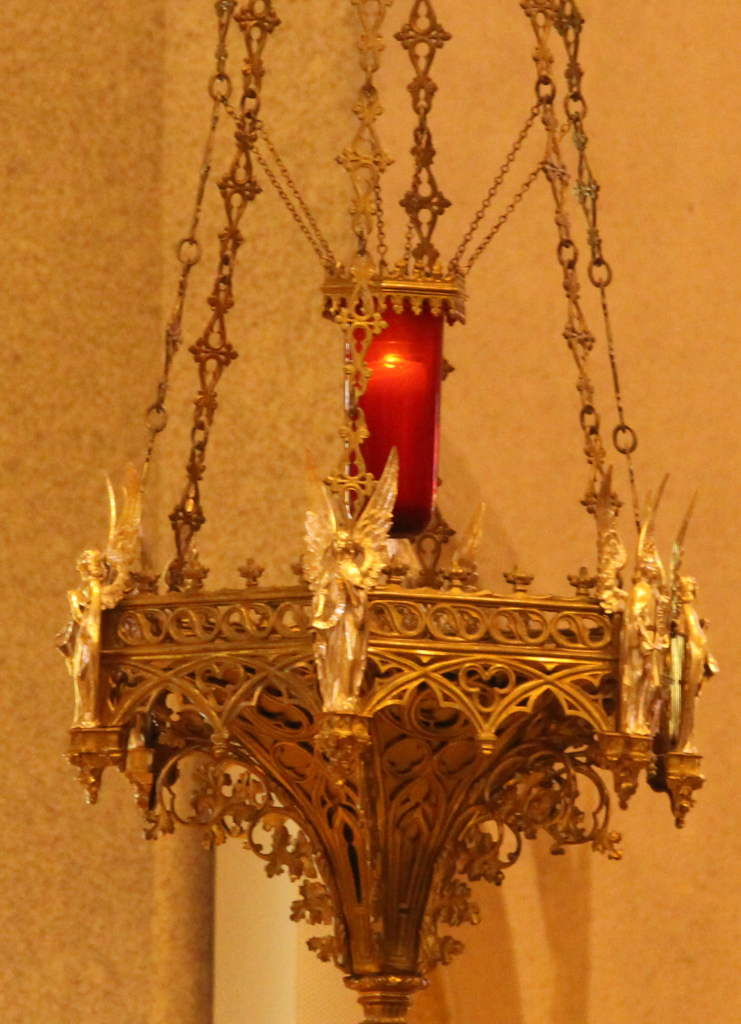 La lampe du sanctuaire est une luminaire rouge allumée tout près du tabernacle et qui annonce que Jésus est présent dans le pain eucharistique (la sainte Réserve) qui s’y trouve